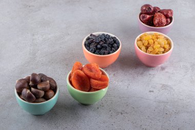 Gri arka planda kurutulmuş meyve ve kestane tabakları