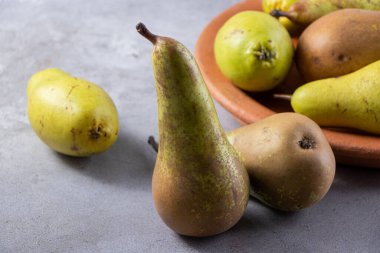 Gri arka planda taze olgun armutlar