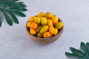 Seramik kasede taze kumkatlar ve yapraklar.