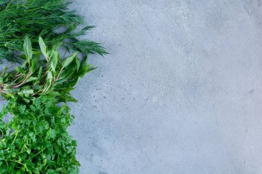 Gri arka planda taze otlar ve yeşiller.