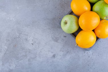 Gri arka planda taze meyveler