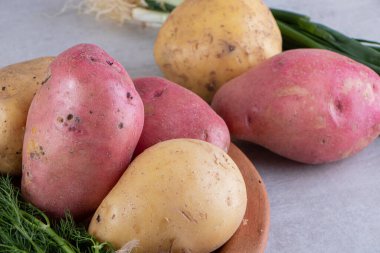 Gri arka planda taze organik patates 