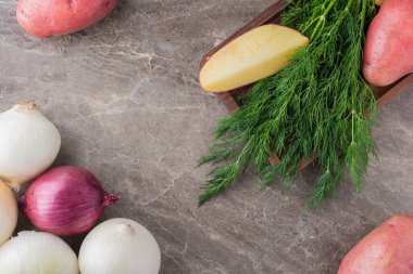 organik soğanlar ve mutfak masasında taze bitkiler.