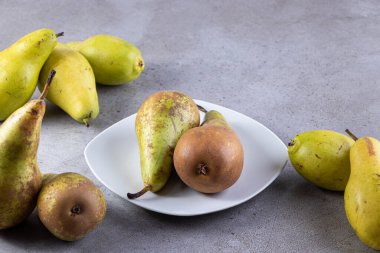 Gri arka planda taze olgun armutlar