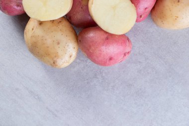 Gri arka planda taze organik patates 