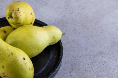 Gri arka planda taze olgun armutlar