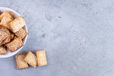 Gri arka planda susamlı ev yapımı kurabiyeler.