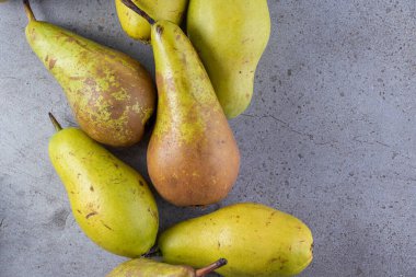 Gri arka planda taze olgun armutlar