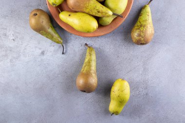 Gri arka planda taze olgun armutlar