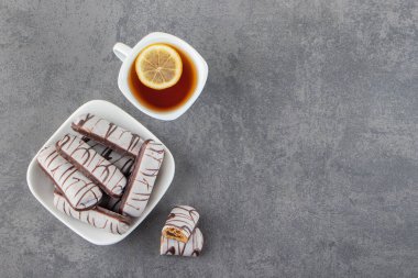 Gri arka planda bir fincan çay ve çikolatalı kurabiye. en üstteki görünüm.