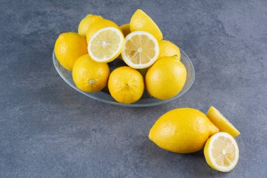 Gri arka planda taze sarı limonlar  