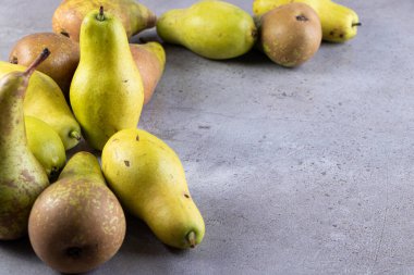 Gri arka planda taze olgun armutlar