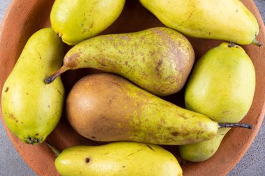 Gri arka planda taze olgun armutlar