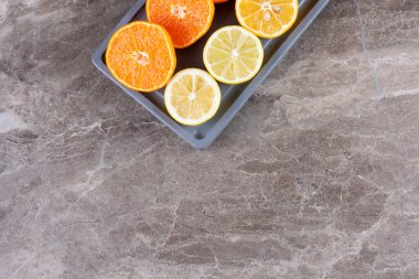 Gri mutfak masasında taze portakallar.