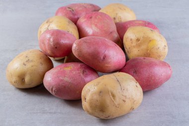 Gri arka planda taze organik patates 