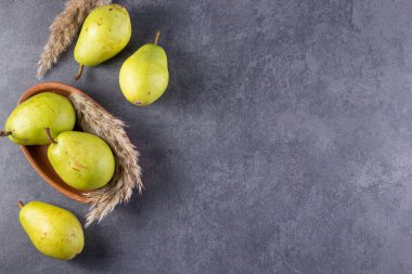 Gri arka planda taze olgun armutlar