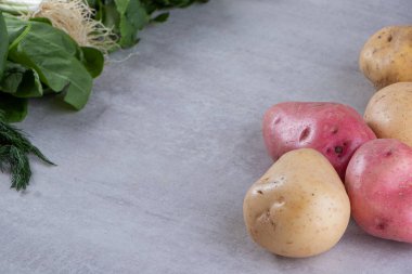 Gri arka planda taze organik patates 