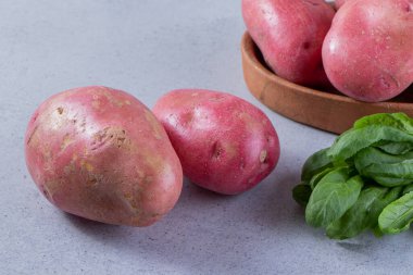 Gri arka planda taze organik patates 