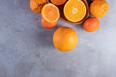 Gri bir masada taze taze portakallar 