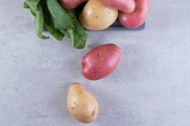 Gri arka planda taze organik patates 