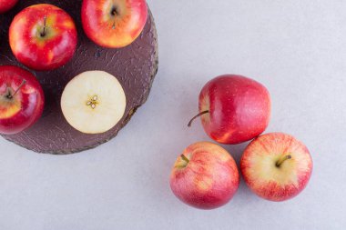 Gri arkaplanda taze kırmızı elmalar var. 