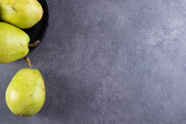 Gri arka planda taze olgun armutlar