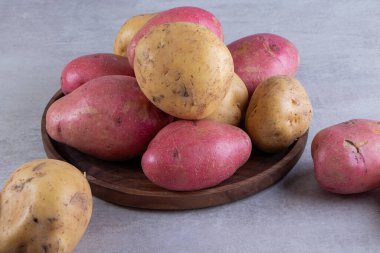Gri arka planda taze organik patates 