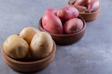 Gri arka planda taze organik patates 