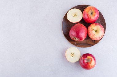 Gri arkaplanda taze kırmızı elmalar var. 