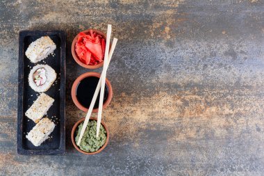 Yemek çubuğu ve soya soslu çeşitli suşi dürümlerinin üst görüntüsü.