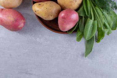 Gri arka planda taze organik patates 