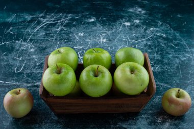 Koyu arkaplanda tahta bir kutuda yeşil elmalar.. 