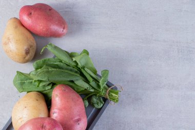 Gri arka planda taze organik patates 