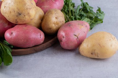 Gri arka planda taze organik patates 
