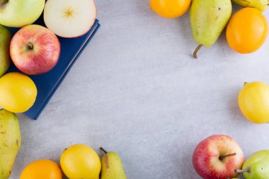 Gri arka planda çeşitli meyveler.