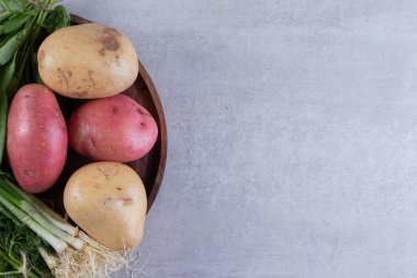 Gri arka planda taze organik patates 
