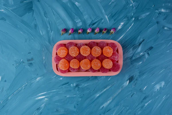 Gri masa arkaplanındaki renkli şekerler