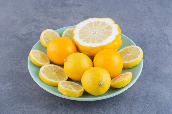 Gri arka planda taze sarı limonlar 