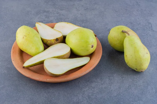 Gri arka planda taze olgun armutlar