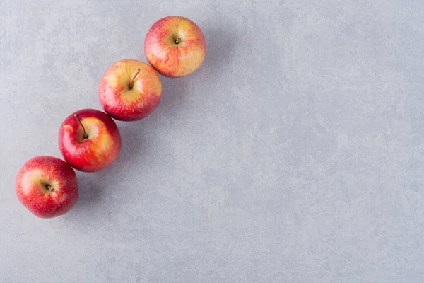 Gri arkaplanda taze olgun elmalar.