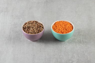 Gri arka plandaki kaselerde farklı mercimek türleri