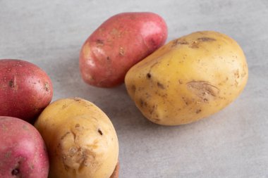 Gri arka planda taze organik patates 