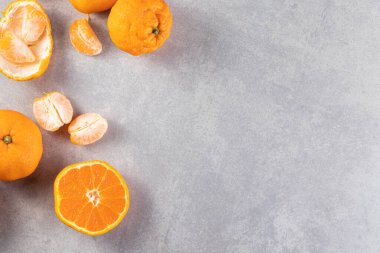 Gri masa arkaplanındaki taze portakallar