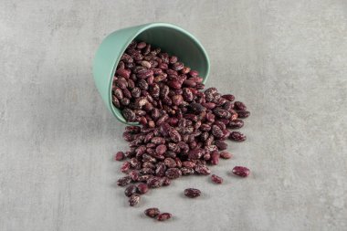 Gri arka planda bir kasede kırmızı fasulye