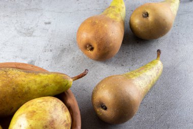 Gri arka planda taze olgun armutlar