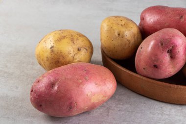 Gri arka planda taze organik patates 