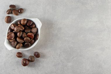 Kestaneler gri arka planda bir kasede