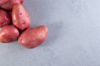 Gri arka planda taze organik patates 