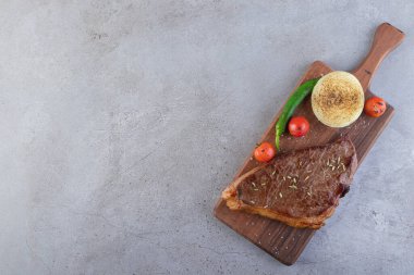 Tabakta pişmiş et ve taş masaya konmuş kızarmış sebzeler. Yüksek kalite fotoğraf