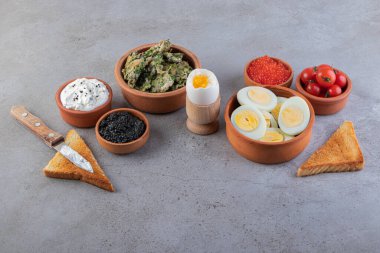 Masada yumurta ve havyarla birlikte kilden yapılmış sağlıklı kahvaltı kaseleri. Yüksek kalite fotoğraf